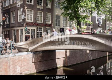 Die Menschen überqueren die stoofbrug, eine 3D gedruckte Brücke, im Rotlichtviertel in Amsterdam, Niederlande. Stockfoto