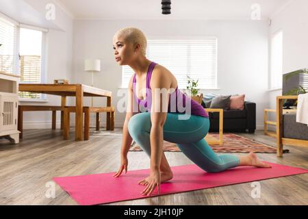 Bild einer Birazialfrau, die zu Hause Yoga praktiziert Stockfoto