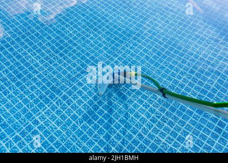 Reinigung des Hauses Pool im Garten mit einer Bürste, ziehen Schmutz vom Boden des Pools. Stockfoto