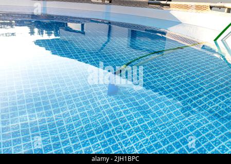 Reinigung des Hauses Pool im Garten mit einer Bürste, ziehen Schmutz vom Boden des Pools. Stockfoto