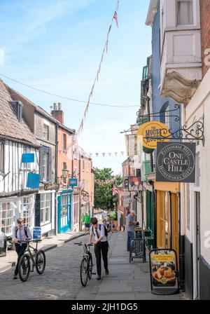 Lincoln, Lincolnshire, Großbritannien, Juni 16 2022 zwei Schuljungen Rollen ihre altmodischen Fahrräder auf Lincolns gepflasterten steilen Hügel. Stockfoto
