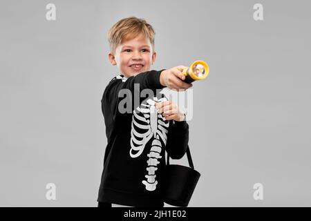 Junge mit Süßigkeiten und Taschenlampe an halloween Stockfoto