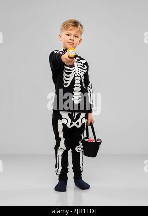 Junge mit Süßigkeiten und Taschenlampe an halloween Stockfoto