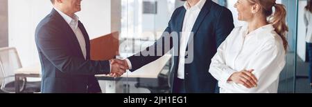 Willkommen in unserem Team, reifen modernen Männer in formeller Kleidung schütteln Hände in modernen Büro Stockfoto