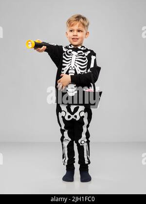 Junge mit Süßigkeiten und Taschenlampe an halloween Stockfoto