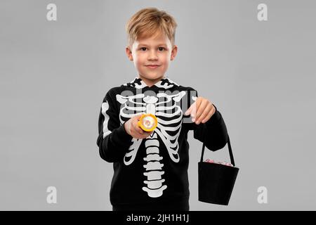 Junge mit Süßigkeiten und Taschenlampe an halloween Stockfoto