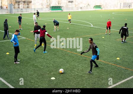 Junge afrikanische Migranten spielen Fußball während eines Trainings, das die Ong SSB am 19. Januar 2021 in Barcelona, Spanien anbietet. Der Ong nutzt Sport, um inte zu fördern Stockfoto