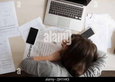 Müde Geschäftsfrau schläft bei der Arbeit, flach liegend Stockfoto