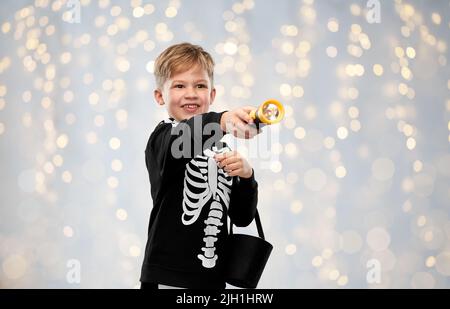 Junge mit Süßigkeiten und Taschenlampe an halloween Stockfoto