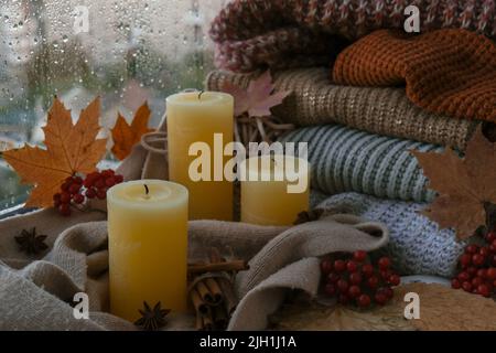 Geblasene Kerze mit Rauch Hallo Herbst, feiern Herbstferien in gemütlichen Hause auf der Fensterbank Hygge Atmosphäre Thanksgiving Blätter, Gewürze und Kerze Stockfoto