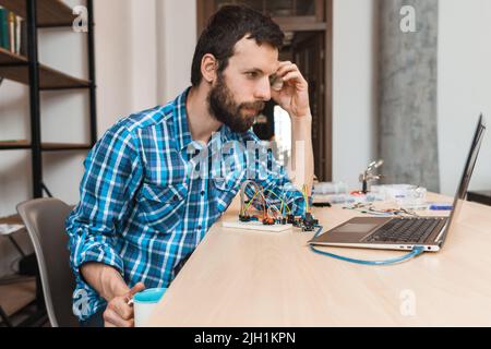 Bärtiger Techniker wartet auf Programmdownload Stockfoto
