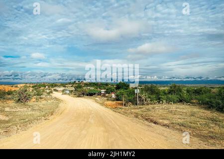 Eine fantastische Aufnahme eines Pfades in der Tatacoa-Wüste mit viel Grün und bewölktem Himmel in Villavieja, Kolumbien Stockfoto