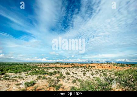 Eine fantastische Aufnahme eines Landes in der Tatacoa-Wüste mit teilweise bedecktem Grün und bewölktem Himmel in Villavieja, Kolumbien Stockfoto