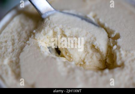 München, Deutschland. 14.. Juli 2022. Ein Löffel steckt in einer Tasse Vanilleeis. Quelle: Sven Hoppe/dpa/Alamy Live News Stockfoto