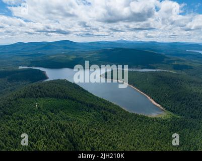 Wolken treiben durch einen blauen Himmel über Clear Lake, in der Nähe von Mount Hood, Oregon. Diese wunderschöne, wilde Gegend ist nur eine Autostunde von Portland entfernt. Stockfoto