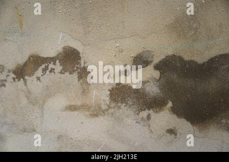 Nahaufnahme einer beschädigten Wand mit feuchten und braunen Flecken. Nützlich für grunge Hintergründe mit Kopierraum Stockfoto