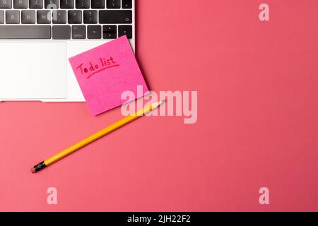 Bild des Laptops, Poste es und Bleistift auf rotem Hintergrund Stockfoto