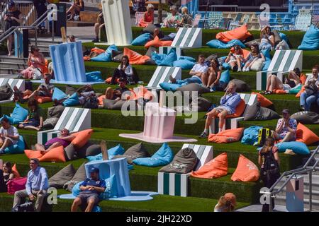 London, Großbritannien. 14.. Juli 2022. Auf der grünen Treppe neben dem Regent's Canal am Granary Square sonnen sich die Menschen neben riesigen „melzenden“ Eislollies, während die Sommer-Kunstinstallation inmitten einer Hitzewelle in der Hauptstadt zum King's Cross zurückkehrt. Kredit: Vuk Valcic/Alamy Live Nachrichten Stockfoto