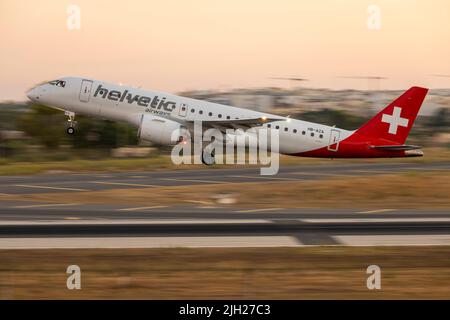 Helvetic Airways Embraer 190 E2 Std (ERJ-190-300STD) (REG: HB-AZA), die nach Sonnenuntergang von 13 abheben. Stockfoto