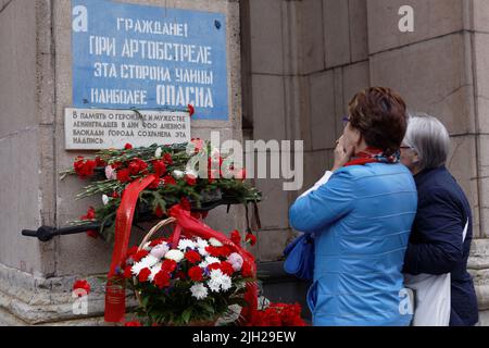 Blumen an der Gedenkstätte Warnung "Diese Straßenseite ist am gefährlichsten während des Beschuss" in der 76.. Jahrestag der Belagerung von Leningrad, St. Petersburg, Russland Stockfoto