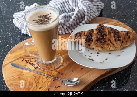 Leckeres Frühstück mit Latte und Schokoladencroissant Stockfoto