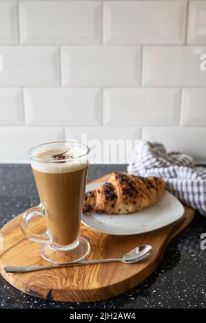 Leckeres Frühstück mit Latte und Schokoladencroissant Stockfoto