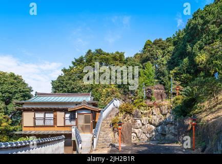 kyushu, japan - 09 2021. dezember: Ein riesiger Megalith-Felsen, der Iwakura-Felsen genannt wird, auf dem Gipfel des buddhistischen Jôjuin-Tempels von Sasebo, umgeben von Th Stockfoto