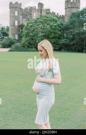 Eine Schwangerin hält den Bauch vor dem Malahide Castle Ireland Stockfoto