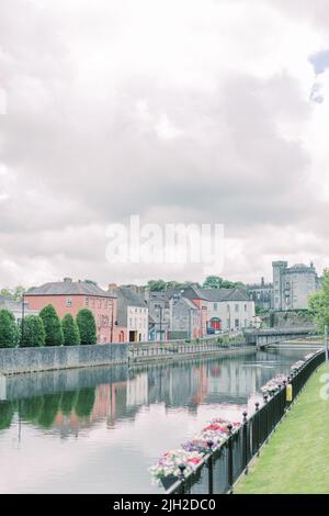 Blick auf den Fluss, die Burg und die bunten Häuser in Kilkenny, Irland Stockfoto