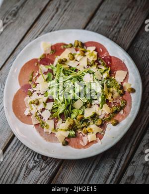 Gourmet-Gericht aus Rindercarpacio mit Rucola und Parmesan Stockfoto