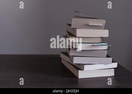 Stapel von Büchern, die zum Lesen bereit sind oder die am Book Day auf einem Holztisch gelesen wurden Stockfoto