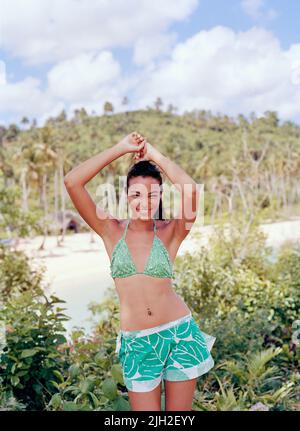 Eine einheimische Frau tanzt auf einem Hügel über dem Strand von Playa Rincon. Halbinsel Samana, Las Galerien, Dominikanische Republik. Stockfoto