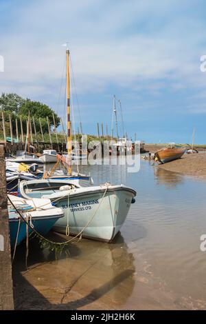 Blakeney Quay, Blick im Sommer auf Boote, die am Kai im nördlichen Norfolk-Dorf Blakeney, Norfolk, England, Großbritannien, festgemacht sind Stockfoto