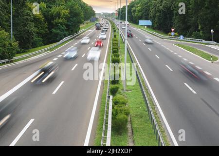 Unscharfer Verkehr auf der Autobahn. Blick auf den Verkehr auf der Autobahn bei Sonnenuntergang Stockfoto