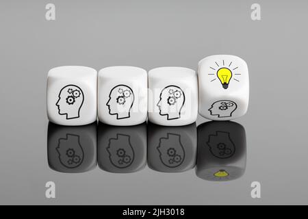 Kreative Idee oder innovatives Konzept zur Ideenentwicklung. Brainstorming in der Gruppe. Weiße Blöcke mit Getriebesymbol und Glühlampe auf dem Flipping Block Stockfoto