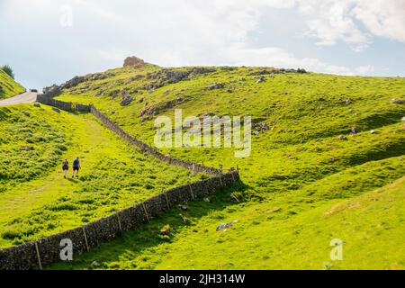 Derbyshire, Großbritannien – 5. April 2018: Zwei kleine Menschen erklimmen den steilen Hügel am Winnats Pass im Peak District National Park Stockfoto