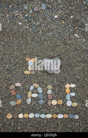 Ich liebe Verkauf aus Steinen am Sandstrand. Heißes Verkaufskonzept Stockfoto