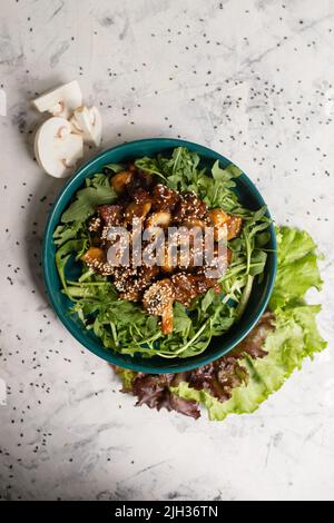 Warmer Salat mit Pilzen und Rucola von oben. Stockfoto