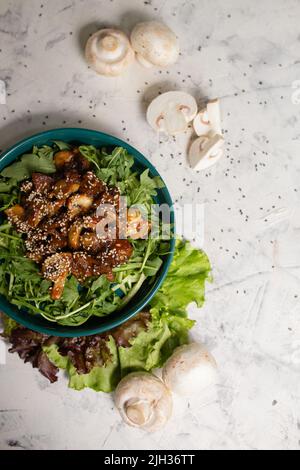 Warmer Salat mit Pilzen und Rucola von oben. Stockfoto