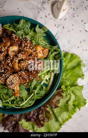 Warmer Salat mit Pilzen und Rucola von oben. Stockfoto