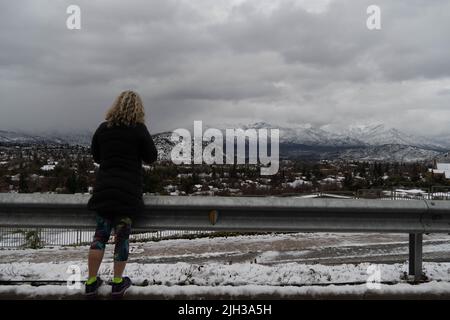 Santiago, Metropolitana, Chile. 14.. Juli 2022. Eine Frau schaut nach einem Schneefall in Santiago, Chile, in die Anden. Kredit: ZUMA Press, Inc./Alamy Live Nachrichten Stockfoto