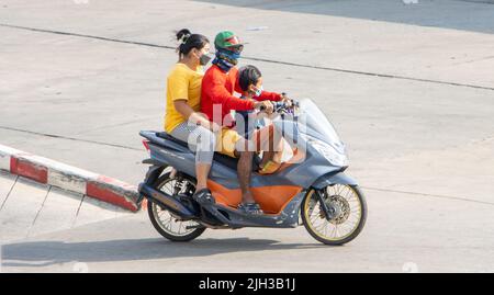 SAMUT PRAKAN, THAILAND, APR 15 2022, Ein Elternteil fährt mit einem kleinen Sohn ein Motorrad. Stockfoto