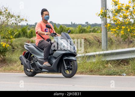 SAMUT PRAKAN, THAILAND, MAI 05 2022, Ein Mann fährt ein Motorrad auf einer Landstraße Stockfoto