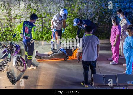 SAMUT PRAKAN, THAILAND, MAI 05 2022, Behandlung eines Motorradkuriers nach einem Unfall Stockfoto