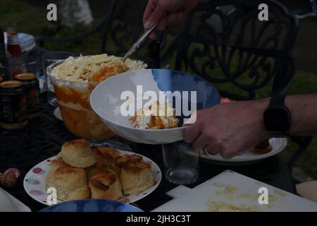 Mann, der die „Platinum Pudding“-Zitrone und Amaretti-Kleinigkeit bei der Street Party serviert, die das Platin-Jubiläum von Queen Elizabeth II in Surrey, England, feiert Stockfoto