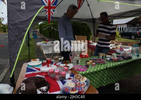 Men by Cake Stand bei der Street Party zur Feier des Platinum Jubilee von Queen Elizabeth II in Surrey England Stockfoto