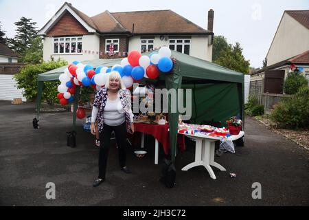 Woman by Cake Stand bei der Street Party zur Feier des Platinum Jubilee von Queen Elizabeth II in Surrey England Stockfoto