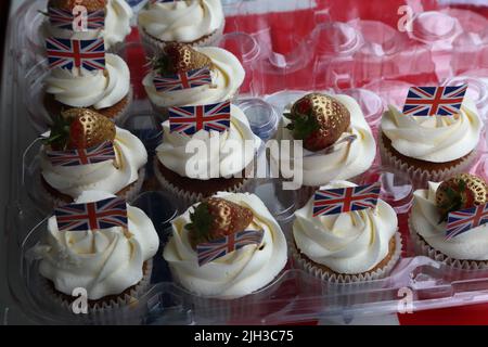 Hausgemachte Cupcakes mit goldenen Erdbeeren und Union Jack Flags bei der Street Party zur Feier des Queen Elizabeth II Platinum Jubilee Surrey England Stockfoto