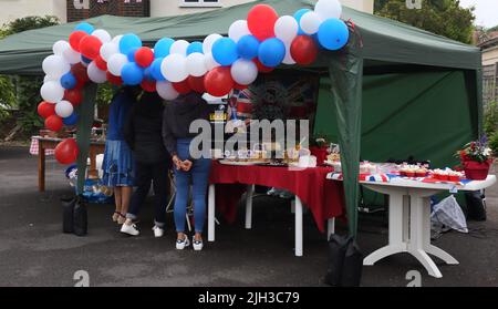 Frauen, die sich hausgemachte Schwämme und Cupcakes am Cake Stand bei der Street Party angucken, um das Platin-Jubiläum von Queen Elizabeth II in Surrey England zu feiern Stockfoto