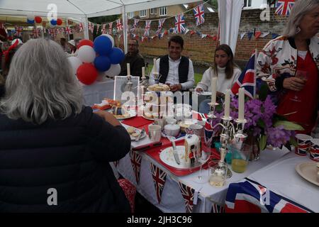Menschen, die Nachmittagstee bei der Street Party feiern, um das Platin-Jubiläum von Queen Elizabeth II in Surrey England zu feiern Stockfoto